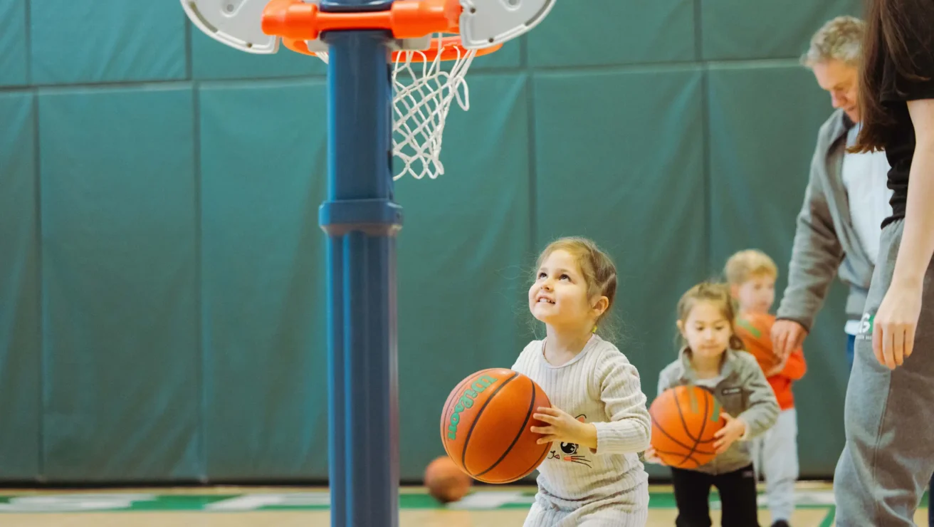 A girl playing youth basketball in a gym.