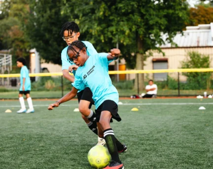 Two young athletes stay active in an Asphalt Green Soccer Club program.